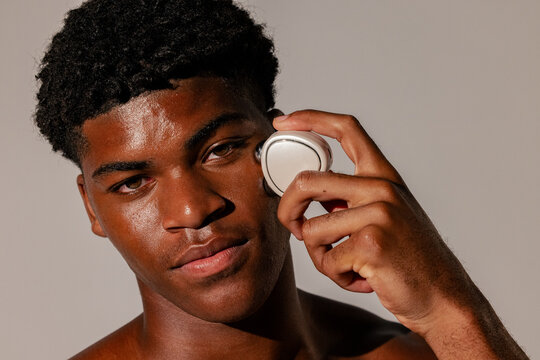 Man Using Facial Massage Device with Calm Expression