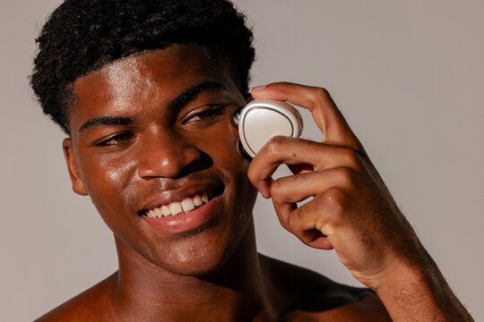 Man Using Facial Massage Device on Cheek