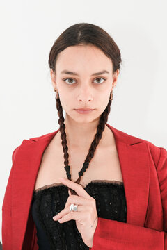 Young woman with braided hair wearing a red blazer and black top
