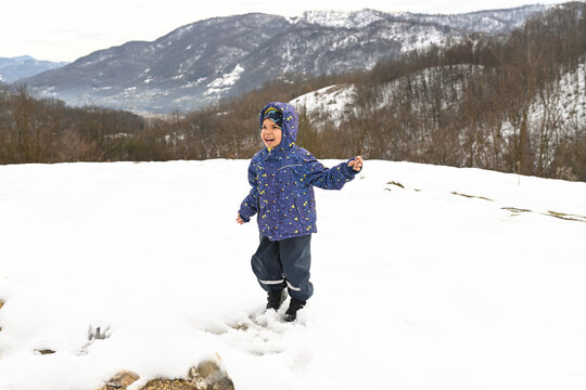 Smiling Child in Winter Clothes Enjoying Snowy Outdoors