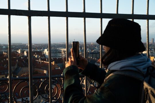 A man taking a photo on a watchtower in Kopenhagen 
