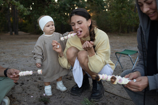 the family cooks marshmallows on the fire