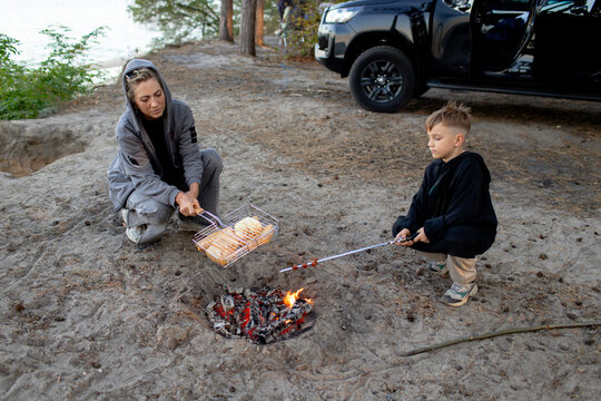 the family cooking hotdogs on a bonfire