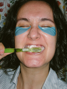 Close Up of Woman with Eye Patches Brushing her Teeth
