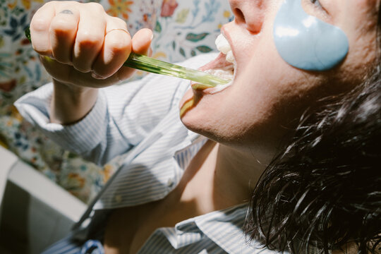 Woman with Eye Patches is Brushing her Teeth