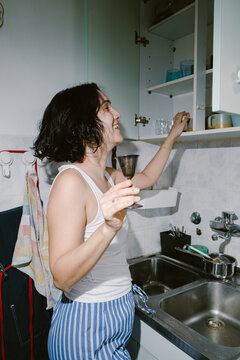 Woman Organizing Kitchen Cabinet at Home