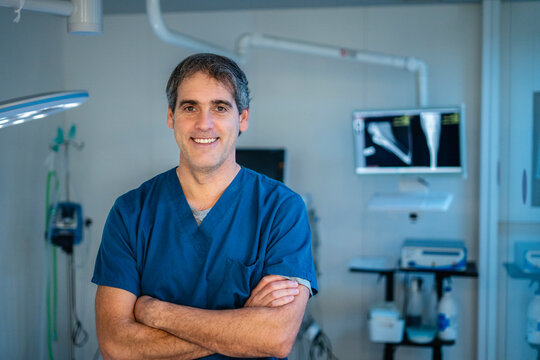 Veterinarian smiling with crossed arms in surgery room