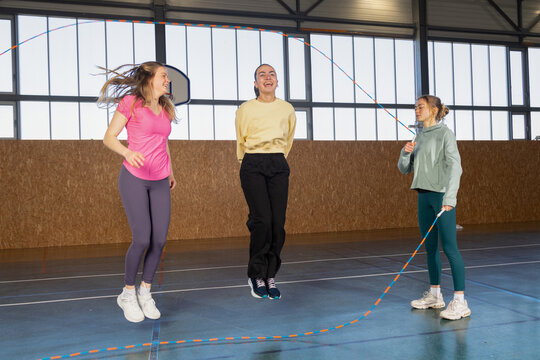 Sportswear girls exercising jumping with skip rope
