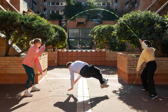 Young people practicing jumping rope with friends 
