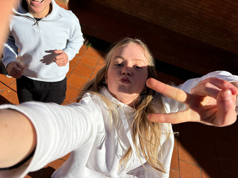 Positive adolescent making V sing in selfie