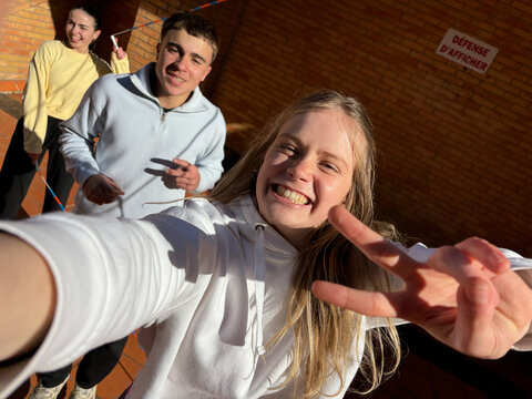Positive adolescent making V sing in selfie