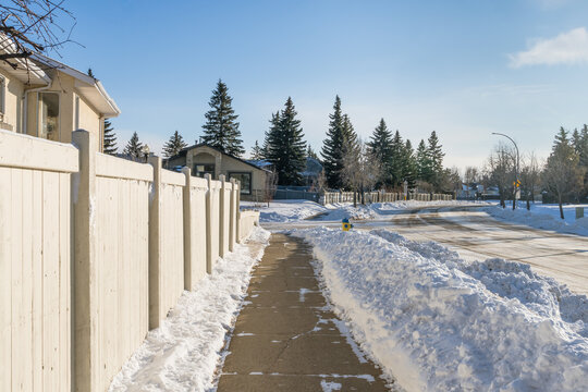 Clean sidewalk  after snow  removed along house property fence in winter season day