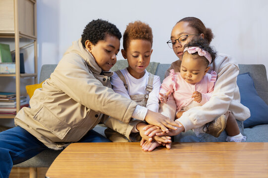 Group of kids playing with hands at home living room