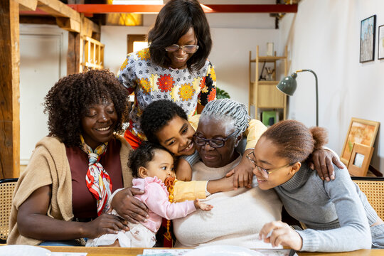 Grandchildren hugging grandmother during family celebration at home