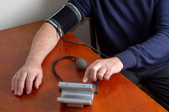 Elderly man measures his blood pressure on his own
