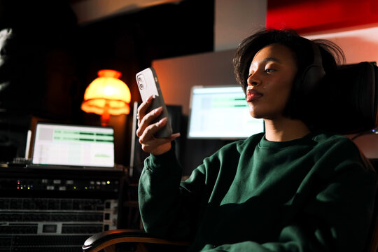 Woman Musician using phone in professional studio