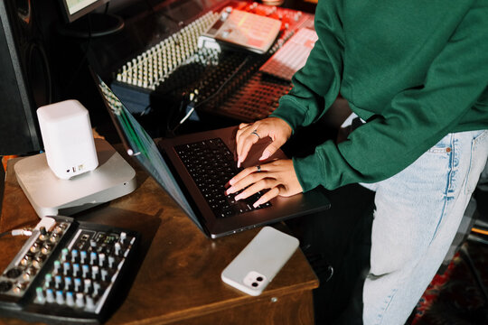 Hands Typing on Laptop in Music Studio