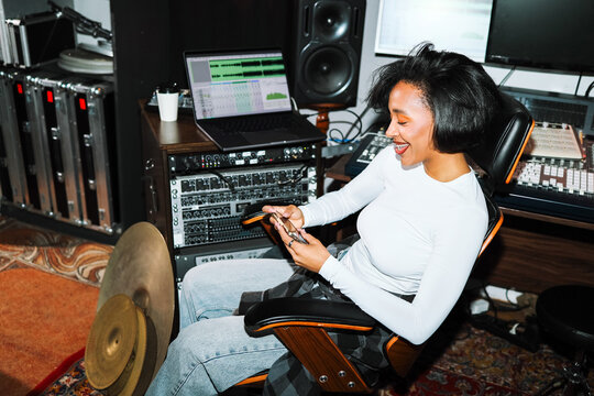 Happy Woman Music Producer in Recording Studio with Phone