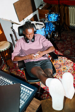 Man Relaxing in Music Studio with Phone