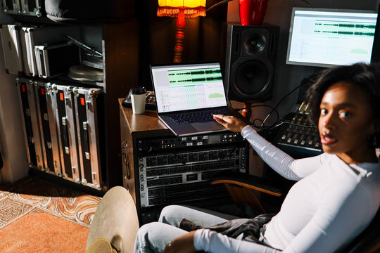 Woman Working on Laptop in  Recording Studio