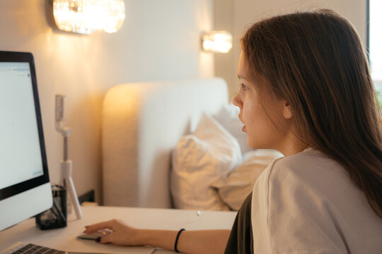Teenager focused on computer work in cozy home environment
