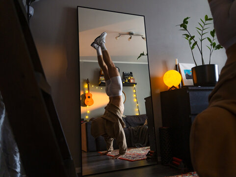 Man Doing Handstand Lifestyle in Mirror At Home