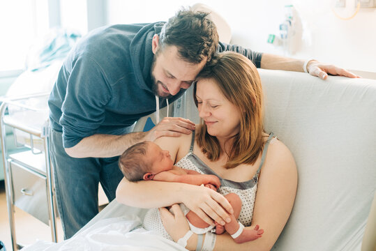 Young Couple Hold Their New Baby in the Hospital