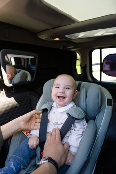 Parents securing baby in car seat for safe travel