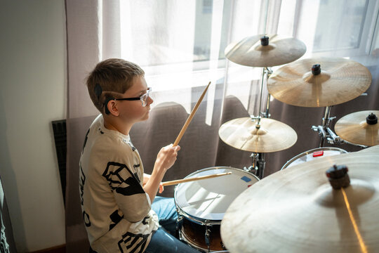 Young boy learning to play the drums in natural light