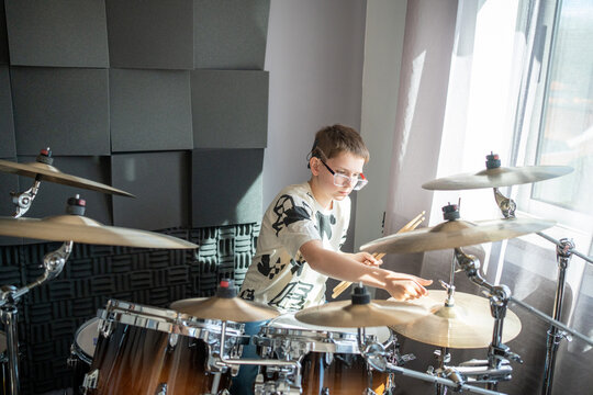 Young drummer practicing in music studio