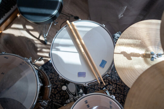 Drum set with drumsticks in sunlight