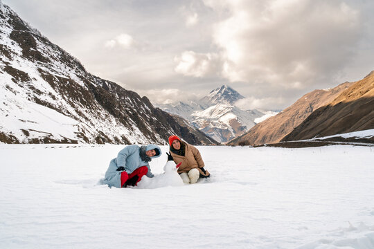 Proud sisters with snowman