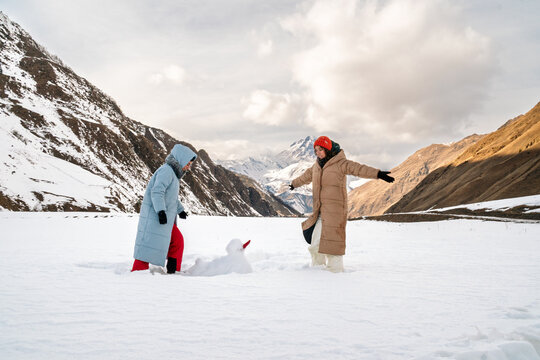 Proud sisters with snowman
