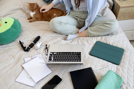 a teenage girl sits on  the bed and teaches lessons