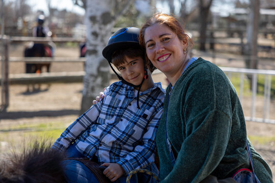 A mother and her young boy pose together, both smiling
