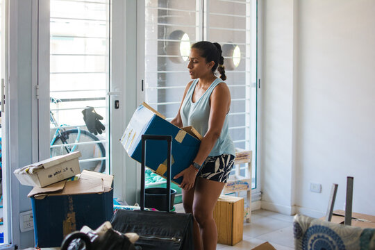 Candid moment of woman lifting heavy box 