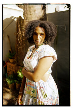 Wide angle portrait of a woman with curly hair looking at the camera