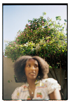 Wide angle portrait of woman with curly hair focusing on background