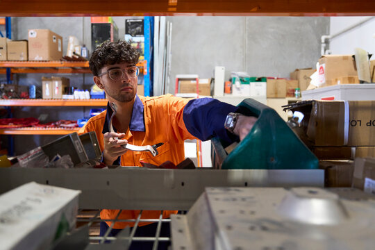 Worker organizing inventory in a warehouse during daytime