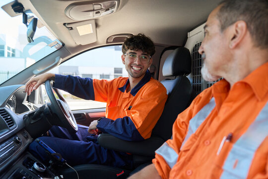 Workers chatting inside utility vehicle on a sunny day at a site