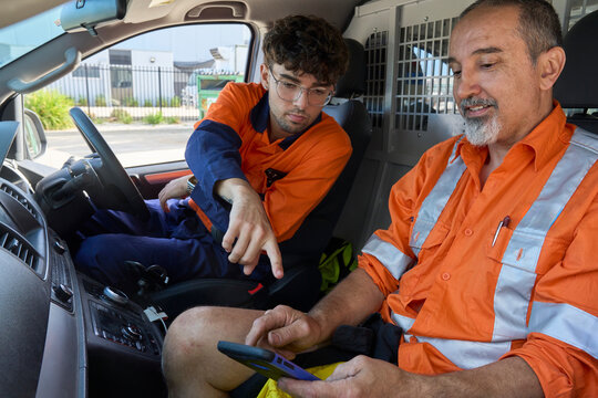 Workers collaborating in a utility vehicle during daylight hours