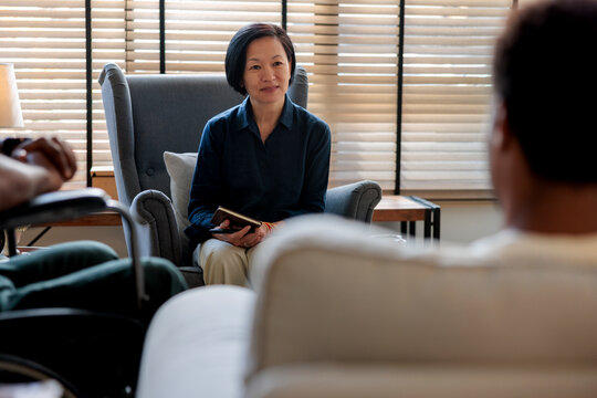 Confident female therapist in armchair discussing with client