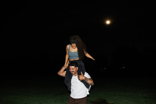 Happy Couple Enjoying a Nighttime Adventure Under a Full Moon