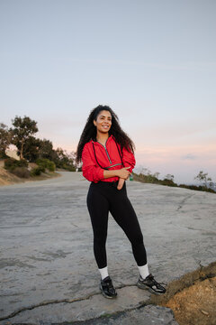 Confident Woman Outdoors in Red Jacket and Black Leggings in Nature