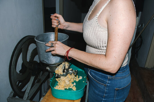 Woman stirring corn in grinding machine