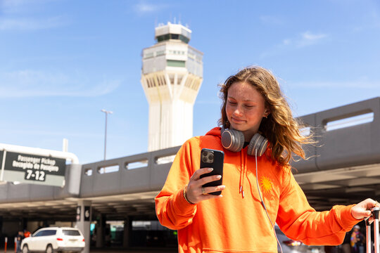 Teen texting cell phone travel airport 