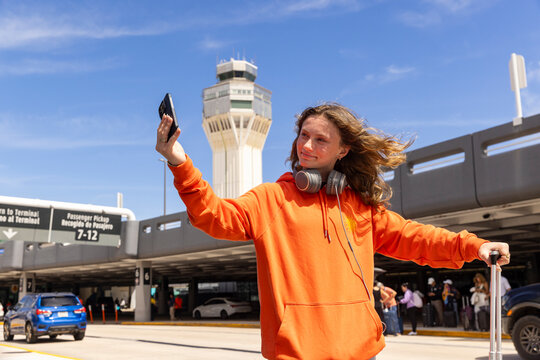 Teen taking selfie  cell phone travel airport 