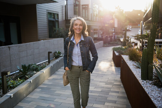 Stylish Woman Walking Outdoors on a Sunny Residential Street