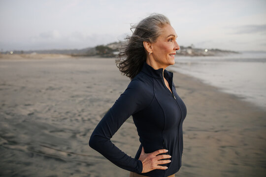 Confident Mature Woman Enjoying Peaceful Evening Walk on Scenic Beach