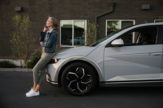 Stylish Woman Standing by Modern Vehicle on Sunny Day